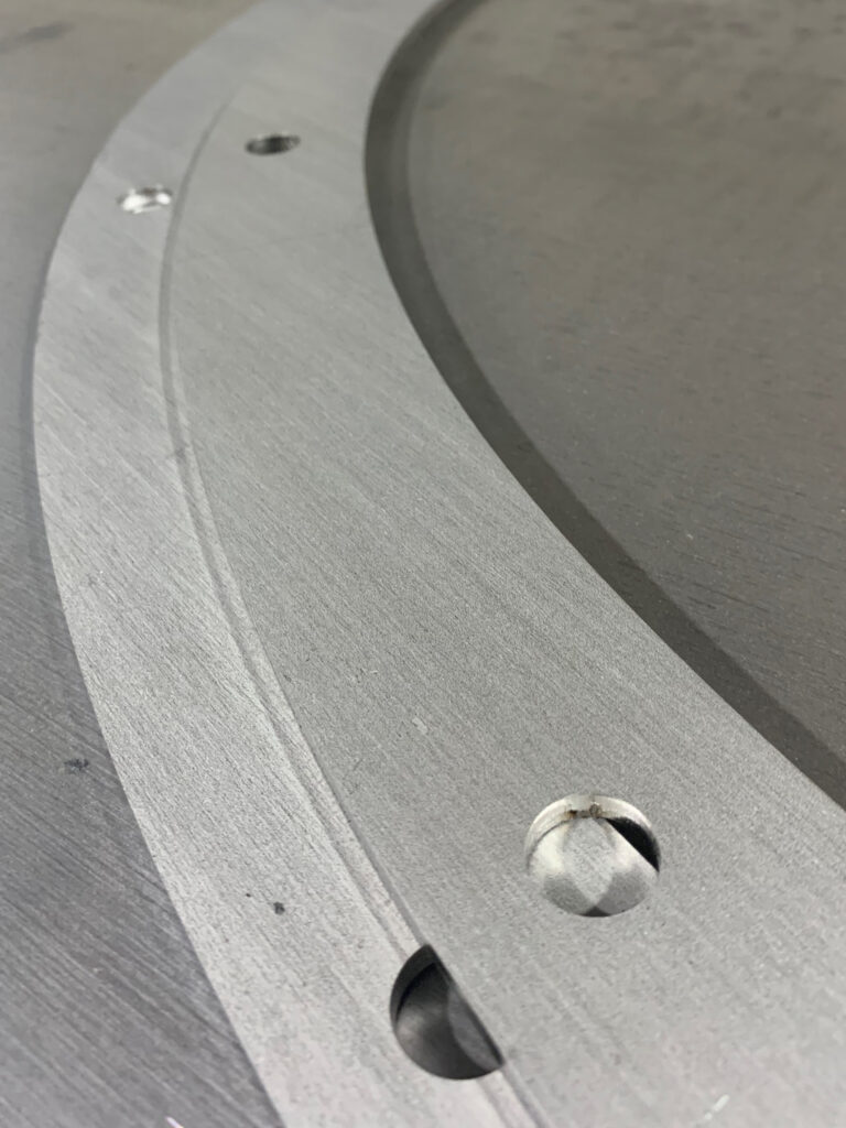 A curved metal component made by The Welmar Group's laser cutter.